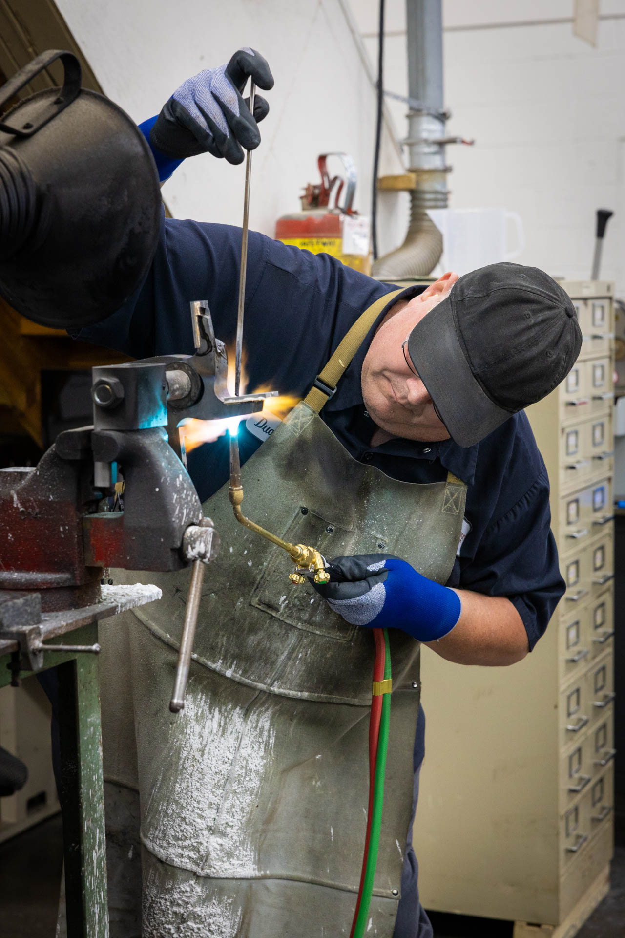 A metal worker welding carbide tips.
